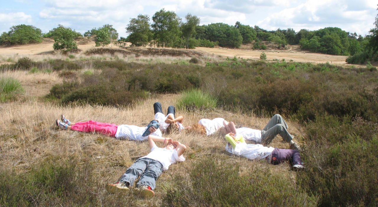 Kinderen liggen in het duin